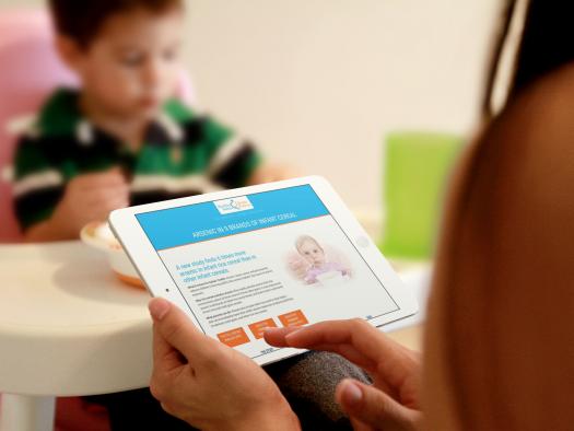 Mother reading Healthy Baby Cereals website on iPad