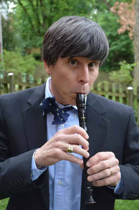 Grown man cosplaying as the Second Doctor, playing the recorder
