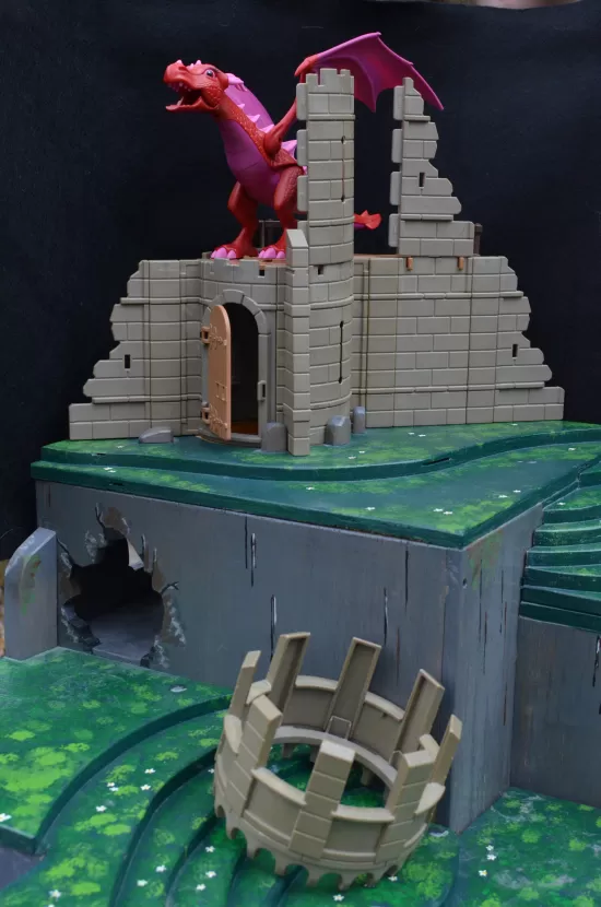 Playmobil castle tower with dragon, atop platform containing secret cave